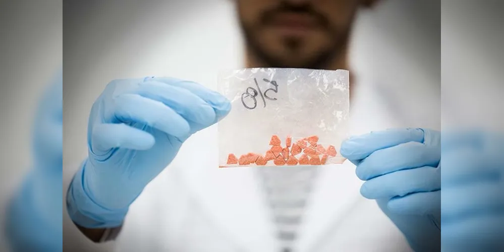Homem segurando material análogo à droga