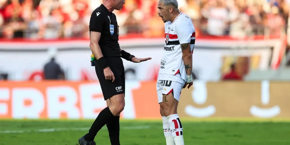 Árbitro e jogador do São Paulo durante partida