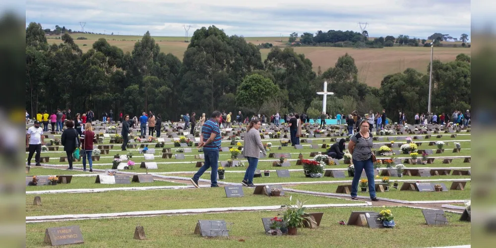 Pessoas visitando seus entes queridos em túmulos
