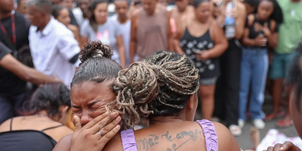 Pessoas chorando após observarem os corpos