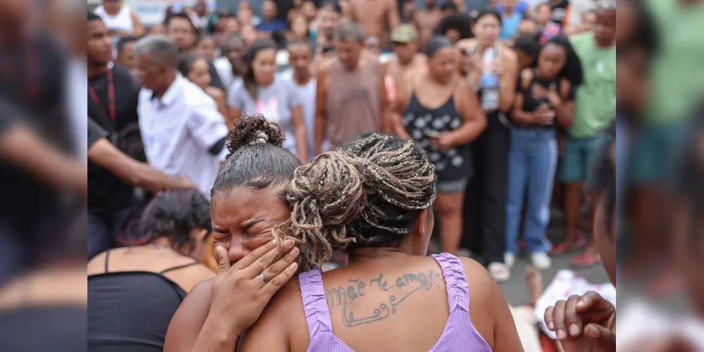 Pessoas chorando após observarem os corpos