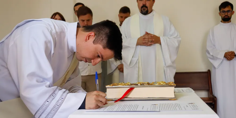 Padre Jefferson Sanchez assinando documento em sua ordenação