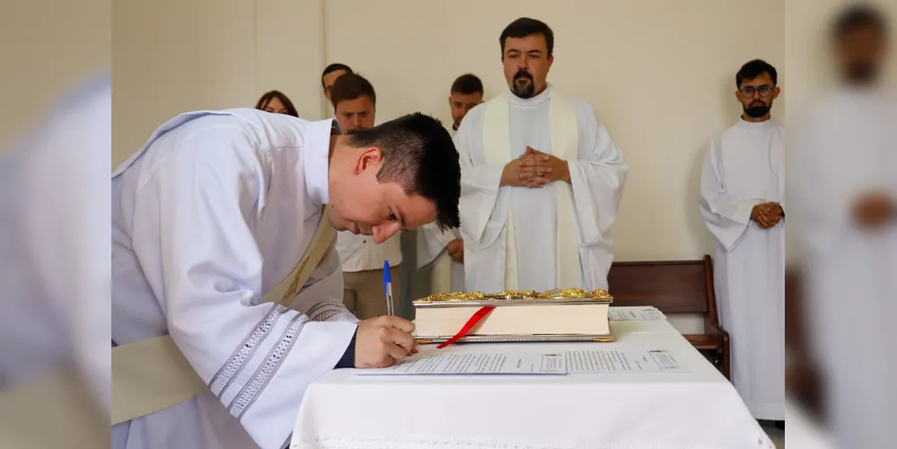 Padre Jefferson Sanchez assinando documento em sua ordenação
