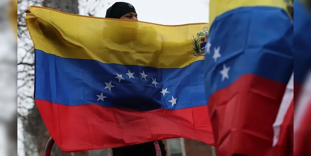 Pessoas seguram bandeiras da Venezuela
