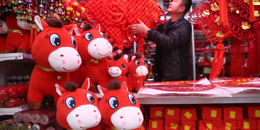 Lojista organiza decoração festiva em Xining, província de Qinghai, na China, para celebrar o Ano do Cavalo