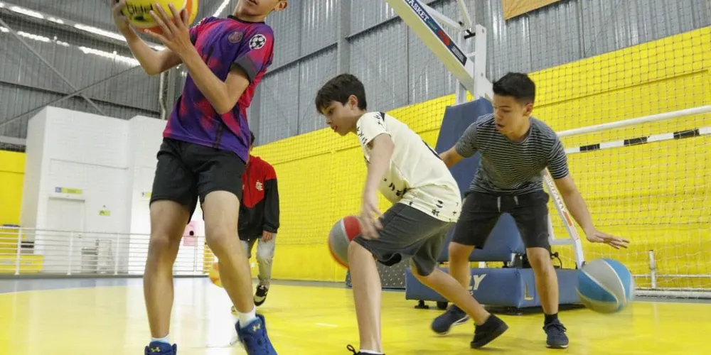 Meninos jogando basquete em ginásio de Ponta Grossa
