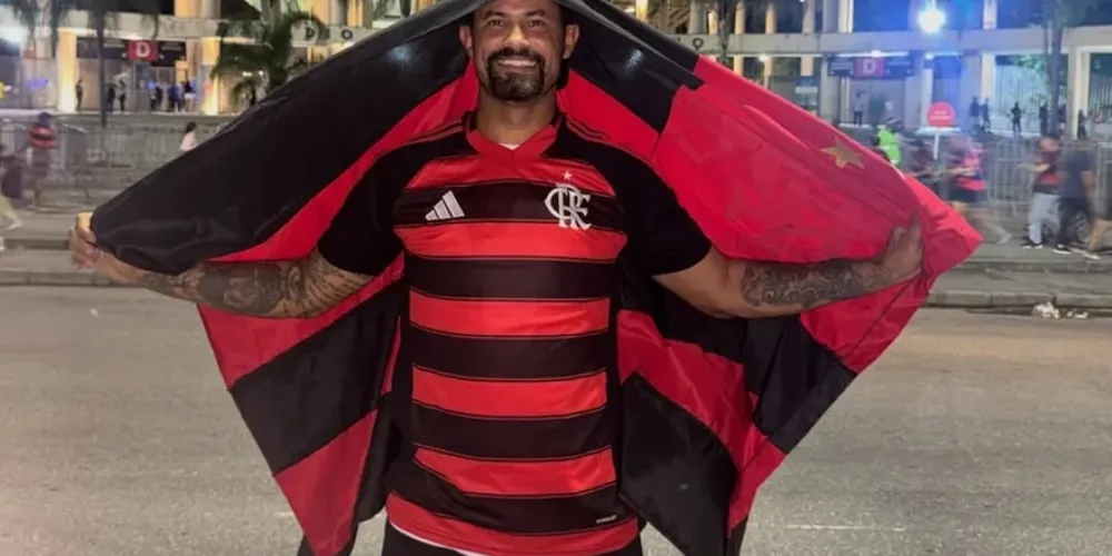 Goleiro Bruno com uma camisa do Flamengo e bandeira do time