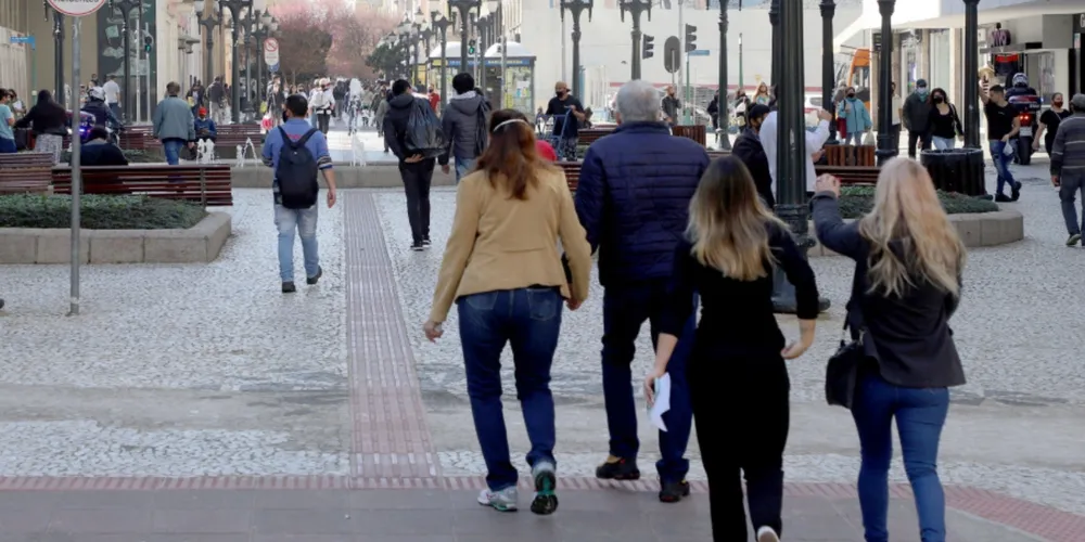 Pessoas caminham com roupas de frio