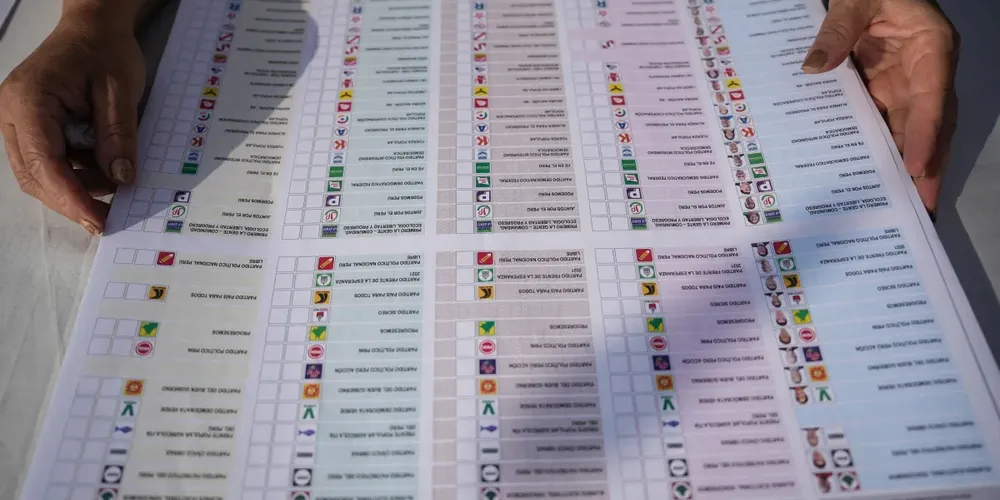 Um funcionário eleitoral manuseia cédula de votação no dia da eleição geral do Peru, em Lima