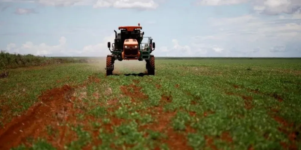Trator espalha fertilizante em um campo de soja próximo a Brasília