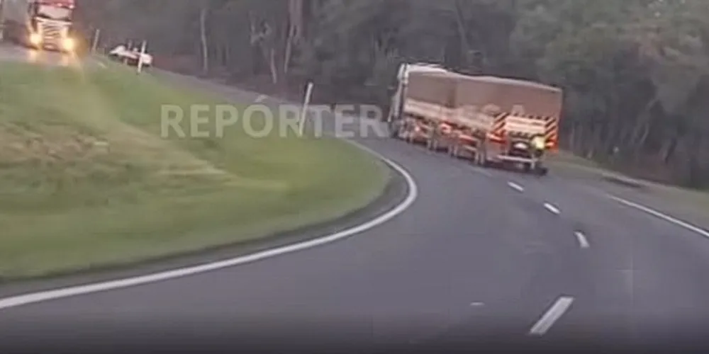 Nas imagens, ele aparece ficando a centímetros de uma carreta em movimento