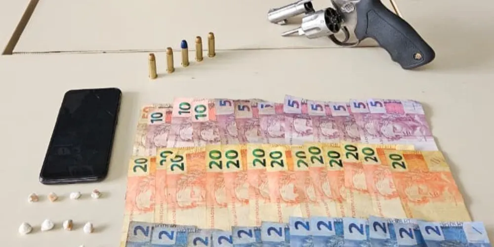 Foram localizados um revólver calibre .38 com cinco munições intactas, 11 pedras de crack (totalizando 2 gramas), R$ 404 em dinheiro e um aparelho celular