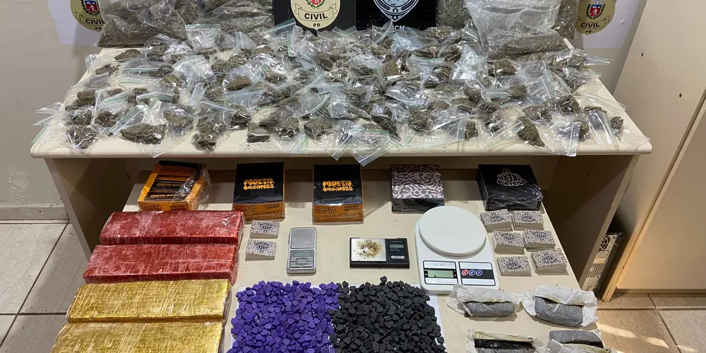 No local, foi apreendida uma expressiva quantidade de entorpecentes organizada sobre uma mesa, parte já fracionada para venda e parte em processo de preparação
