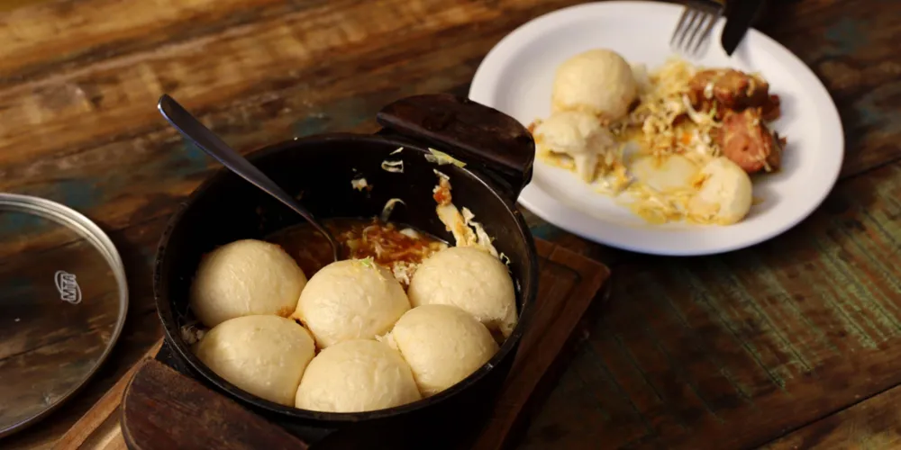 A receita é preparada com três ingredientes principais: carne suína, repolho e pães cozidos no vapor, todos em camadas dentro da panela