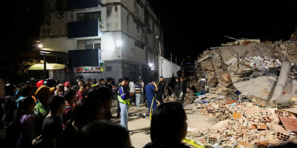 Pessoas se reúnem enquanto equipes de emergência atuam no local de prédio desabado em Caracas após terremotos na Venezuela