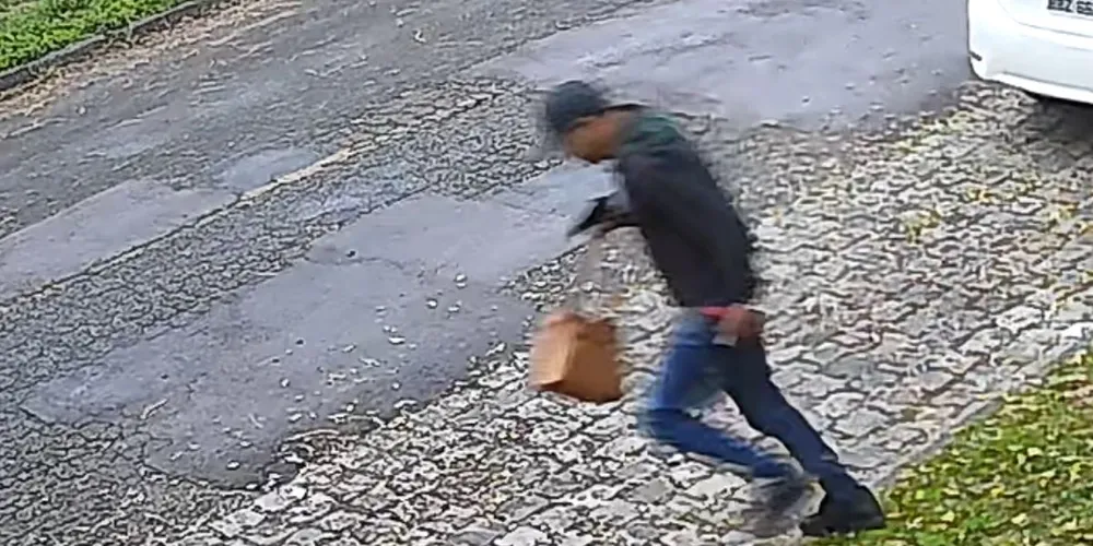 Câmeras de segurança flagraram o momento em que um dos suspeitos deixa o local após o roubo contra uma mulher em Curitiba