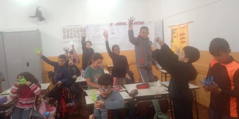 Os alunos desenvolveram uma experiência de robótica "desplugada", utilizando materiais como EVA, canudinhos, cola e fios para confeccionar uma mão robótica