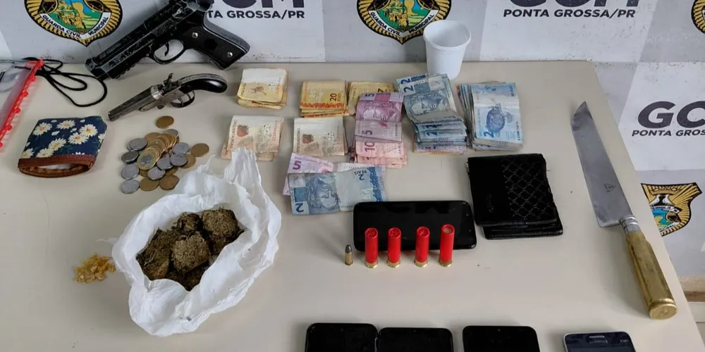 A abordagem resultou na apreensão de uma arma de fogo, munições, porções de entorpecentes, dinheiro e aparelhos celulares