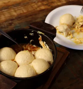 A receita é preparada com três ingredientes principais: carne suína, repolho e pães cozidos no vapor, todos em camadas dentro da panela