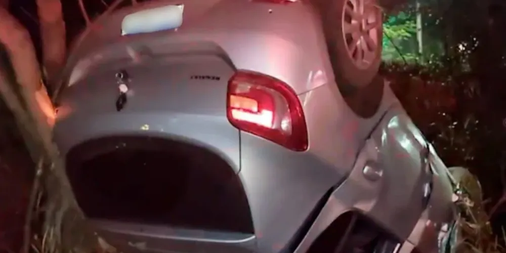 O carro, um Renault Sandero, ficou bem danificado e virado com as rodas para o alto