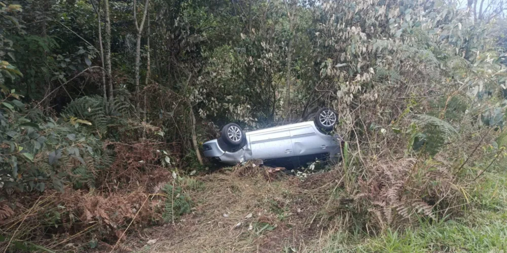 O veículo é um Volkswagen Fox, que capotou às margens da rodovia