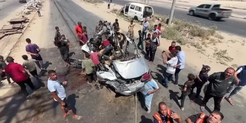 Palestinos verificam as consequências do ataque israelense a um veículo em Deir al-Balah, na Faixa de Gaza
