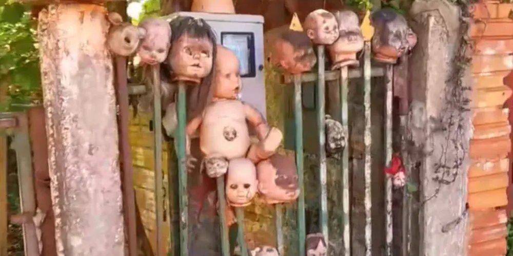 O acervo exótico de brinquedos espetados no portão virou atração no bairro e divide opiniões na internet