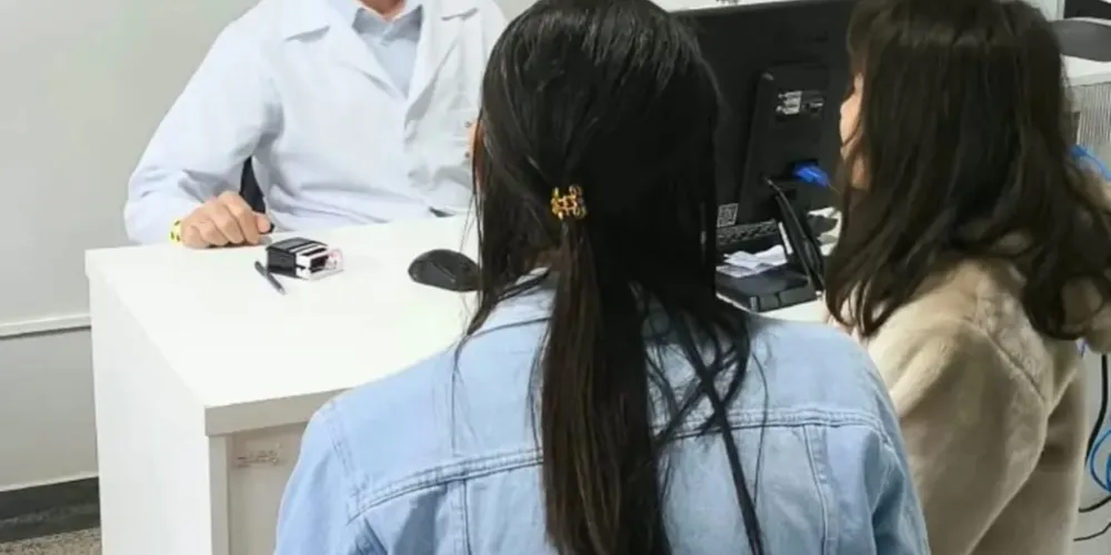Mãe e filha sendo atendidas por médico