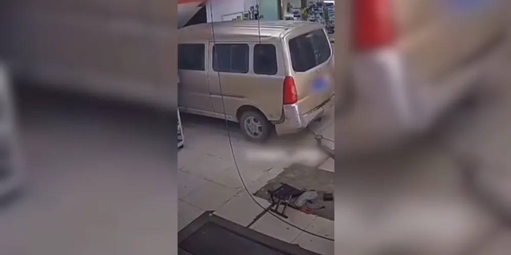 O veículo, que estava elevado em um equipamento hidráulico, avança e bate contra a parede do estabelecimento.
