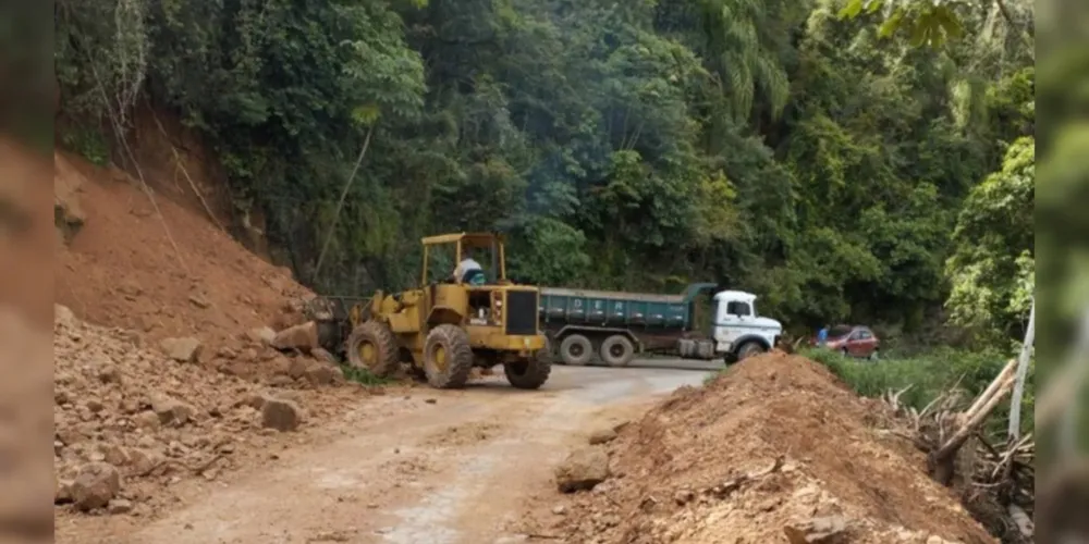 Equipes utilizam retroescavadeira para remover a terra e recuperar o trecho atingido na PR-092