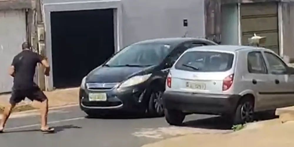 O carro passa pela via e atropela o homem, que cai no chão