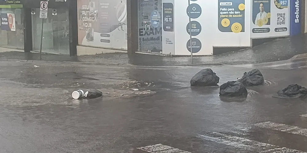 Sacos de lixo são arrastados pela chuva na Avenida Bonifácio Vilela em Ponta Grossa
