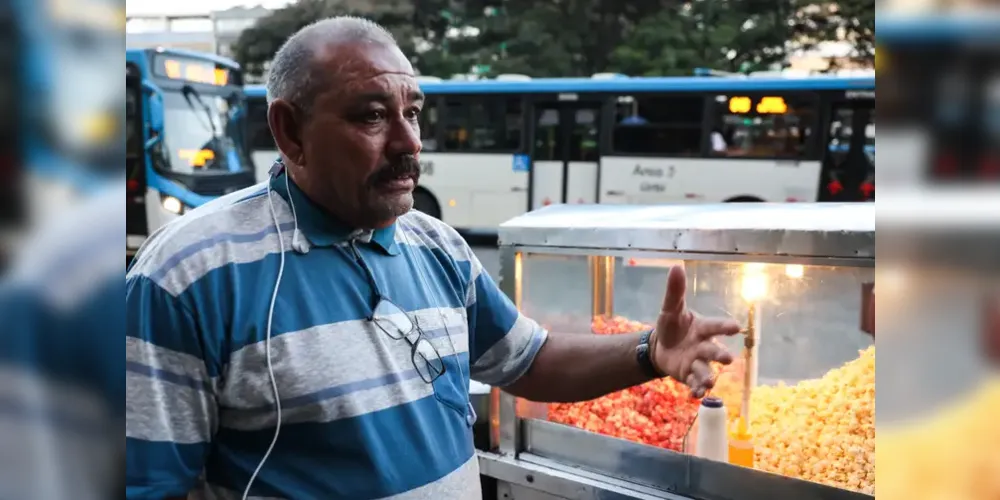 Enquanto vende pipoca, Gil Lopes usa os fones para ouvir mensagens dos filhos