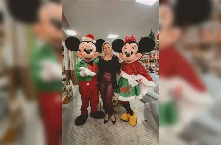 Luciane Nunes de Freitas dos Santos ladeada pelo Mickey e Minie Noel