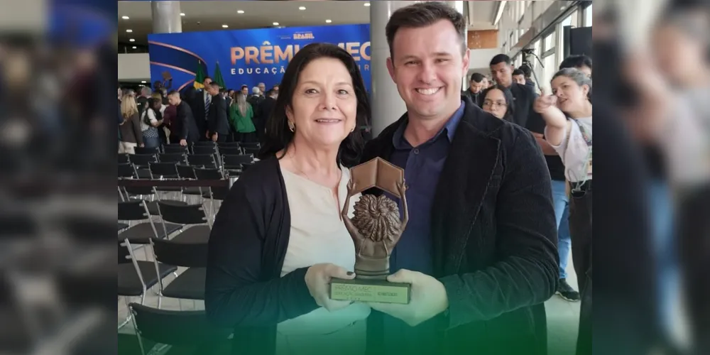 William Kriger, diretor da escola, e Claudia Maria Portela, Secretária Municipal de Educação, recebem o troféu