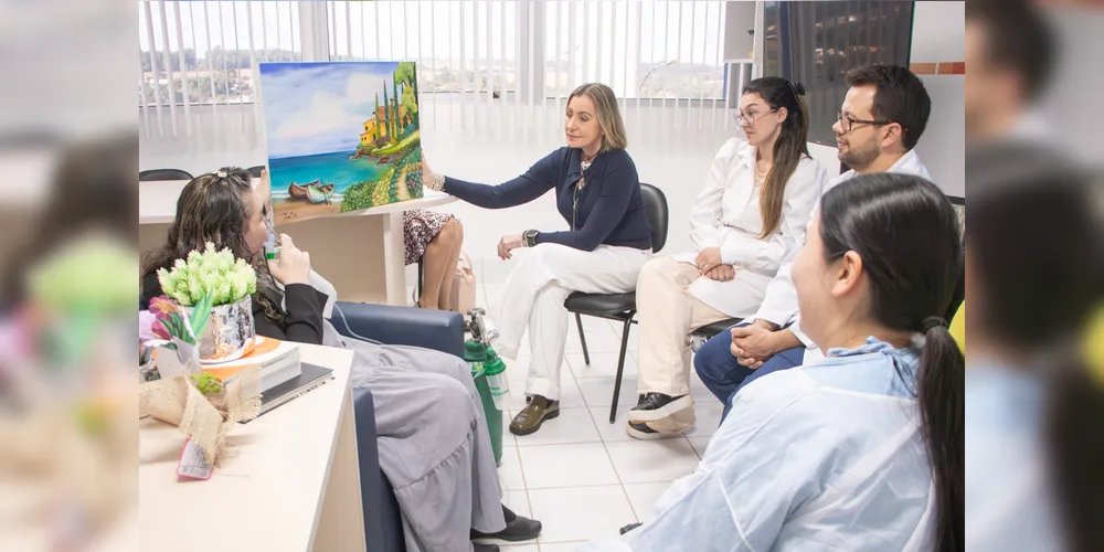 Rosangela pintou um quadro e entregou o presente aos funcionários do HU