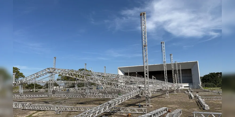 Equipes trabalham na montagem da estrutura, organização do espaço