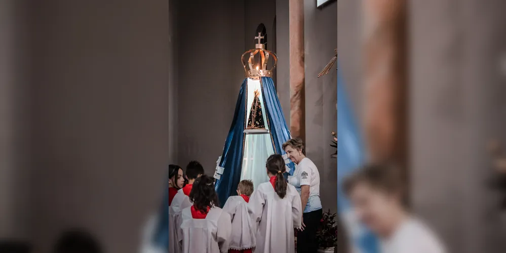 Ao longo das novenas, as crianças oferecem flores à Nossa Senhora