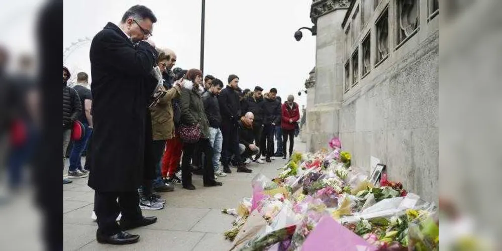 Pessoas observam homenagens às vítimas do atentado em Londres/ Foto: Hannah Mckay/ EPA/ Lusa