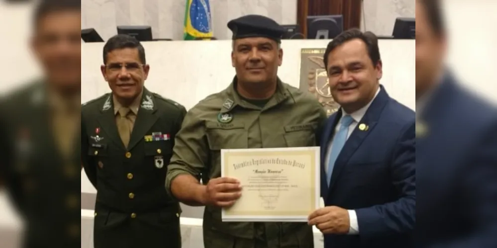 Lucio Barbosa, presidente da Associação, recebendo a homenagem das mãos do  deputado Subtenente Everton. Ao lado, o General de Brigada Aléssio Oliveira da Silva.