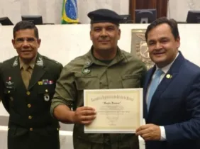 Lucio Barbosa, presidente da Associação, recebendo a homenagem das mãos do  deputado Subtenente Everton. Ao lado, o General de Brigada Aléssio Oliveira da Silva.
