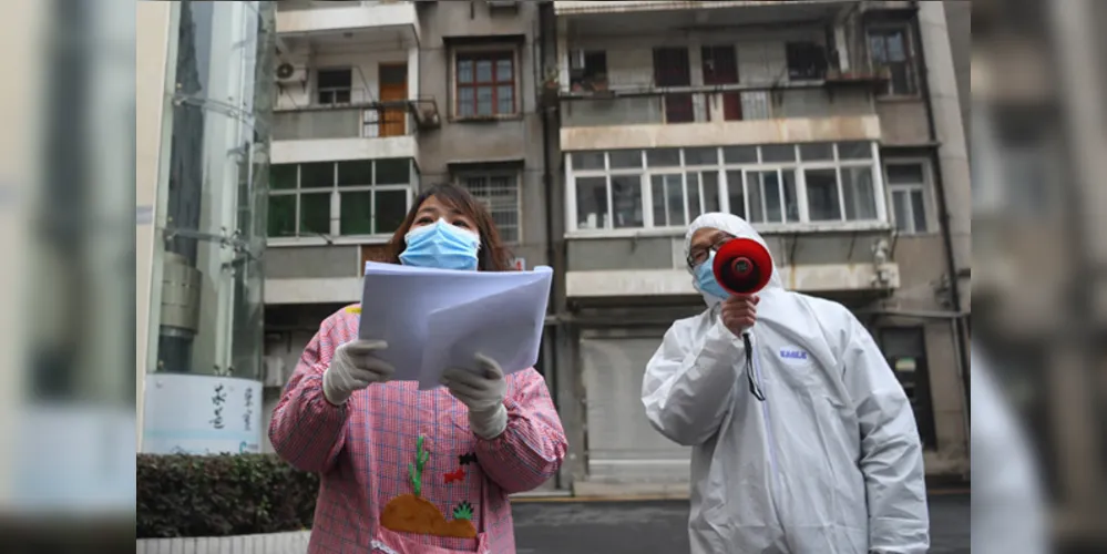Os trabalhadores comunitários verificam as informações dos residentes no distrito de Jiangan, em Wuhan, província de Hubei, na China Central Wuhan, o epicentro do novo surto de coronavírus