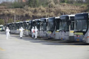 Os funcionários desinfetam os ônibus em Yichang, província de Hubei, na China Central