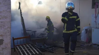 Casa de madeira foi destruída rapidamente pelo fogo, mas bombeiros salvaram outros imóveis