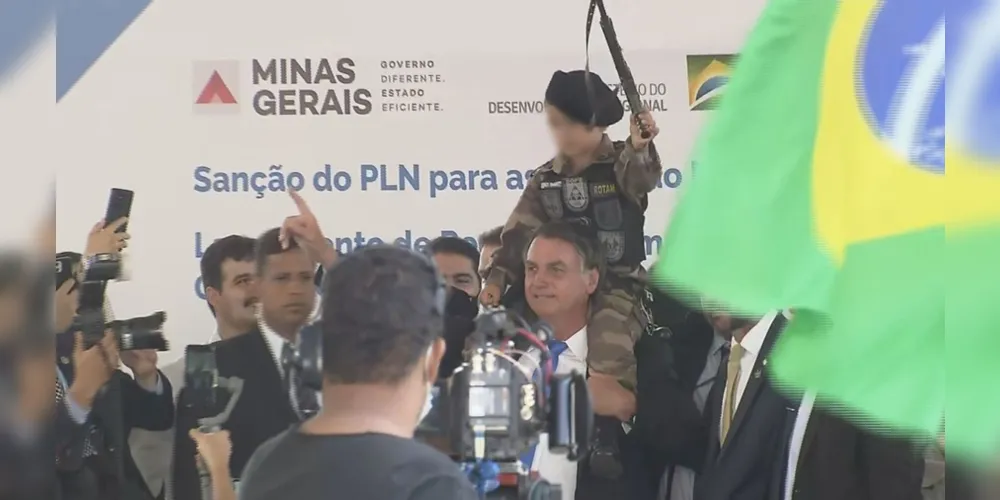 Bolsonaro posa para fotos com criança fardada e com arma de brinquedo na mão, em Belo Horizonte.