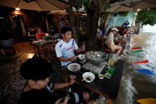 Estabelecimento da Tailândia aposta que refeição boa é aquela que escapa da movimentação do rio, após a passagem de navios