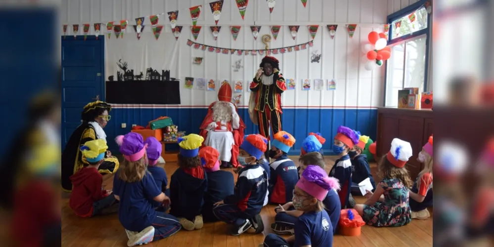 Sinterklaas visita escolas, com seus ajudantes, e distribui presentes.