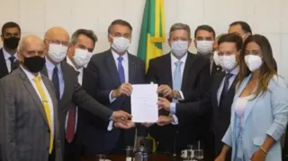 Presidente Jair Bolsonaro rodeado por parlamentares durante entrega da MP do Auxílio Brasil, em agostO