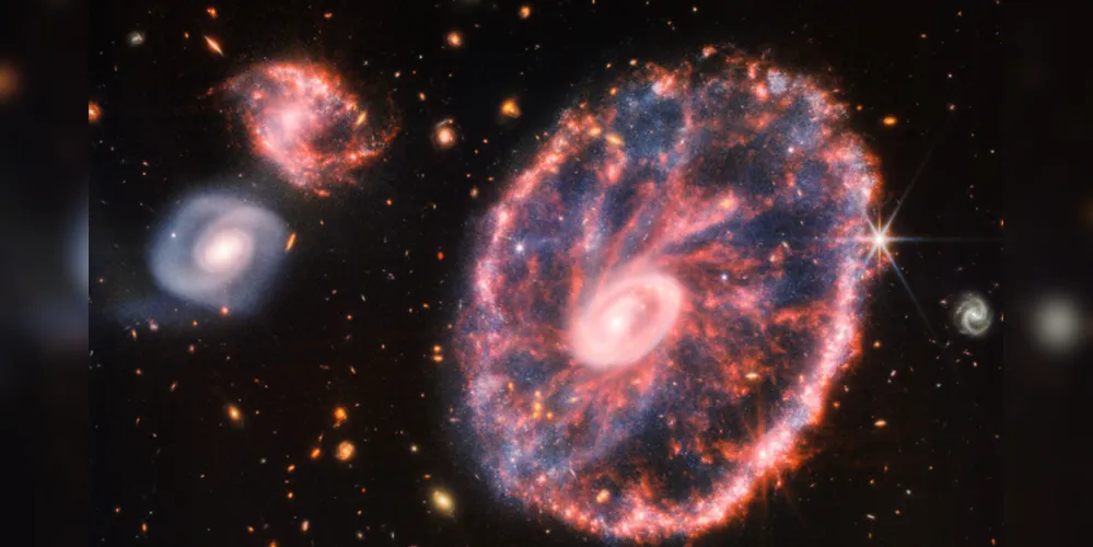 A imagem tem, ao fundo, várias outras galáxias – duas delas com maior destaque.