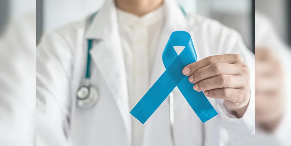 Fita azul simbólica para campanha de conscientização do câncer de próstata e saúde masculina na mão do médico